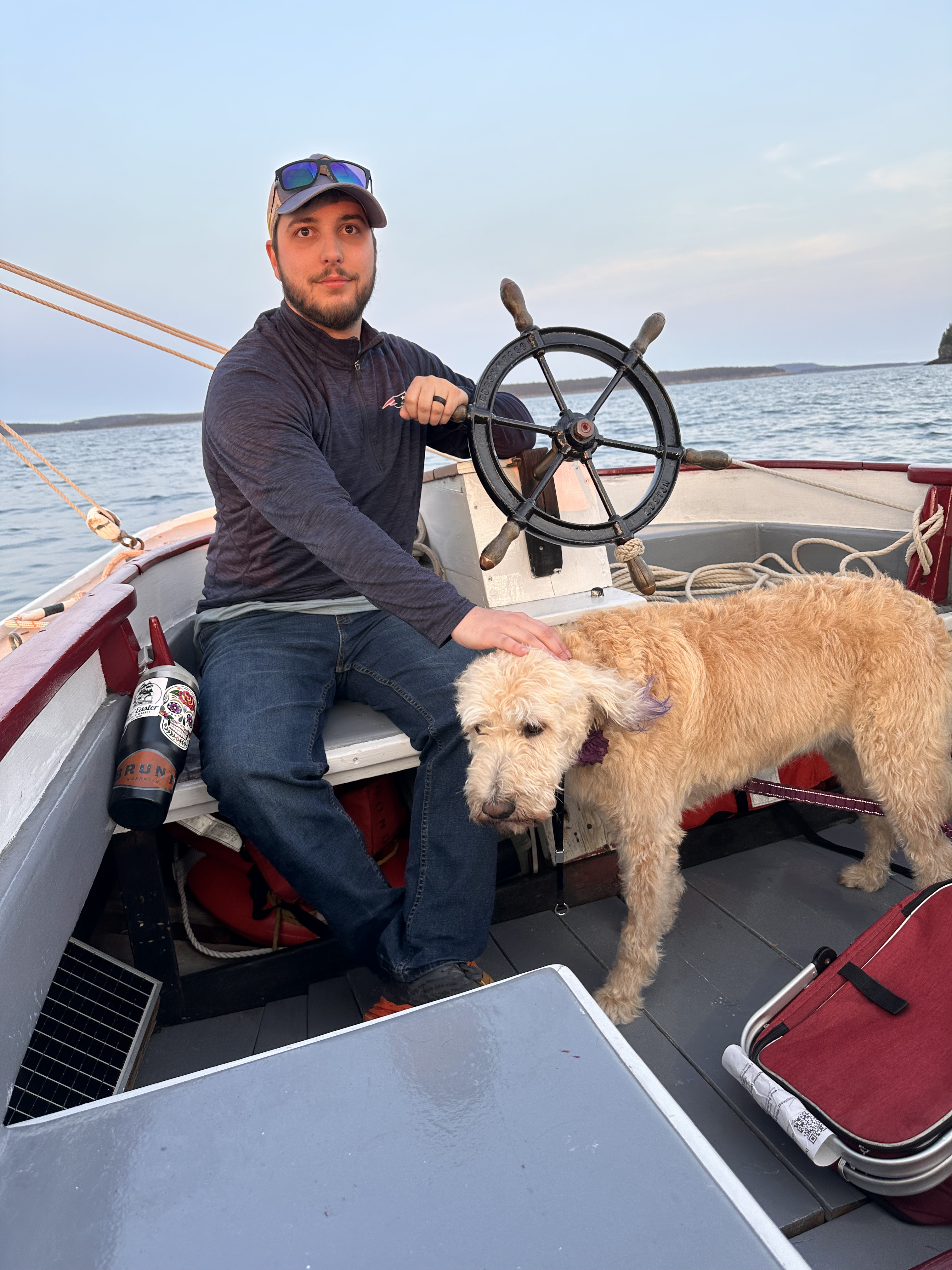 Jeremy on a boat at the helm